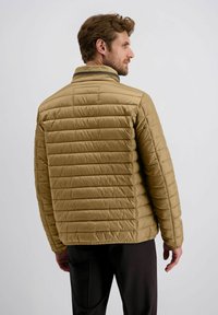 Gef ütterte Jacke in Hellbraun mit horizontalem Steppdesign, Stehkragen und glatter Oberfläche, getragen zu dunklen Hosen.