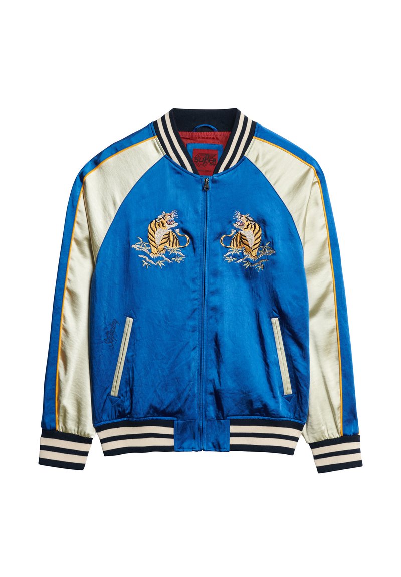 Veste bomber en satin bleu avec des manches en satin blanc, un col et des poignets à rayures noires et blanches, et des motifs de tigre brodés sur la poitrine.