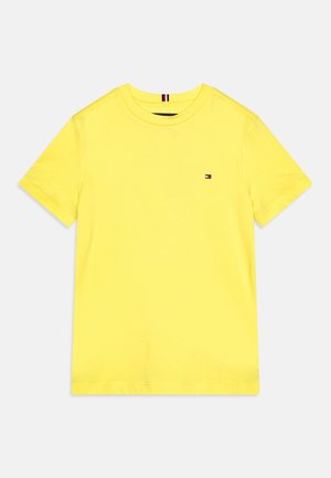 Žluté bavlněné tričko s krátkým rukávem, kulatým výstřihem a malou vyšitou nášivkou na hrudi. Měkká textura a klasický střih.