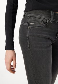 G-Star black denim jeans with a slim fit, featuring contrasting stitching, a small logo tag, and five-pocket design. Textured fabric.