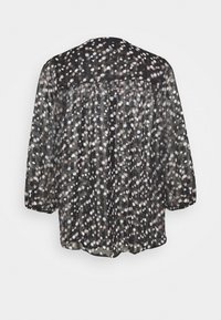 Blusa nera trasparente con maniche lunghe a sbuffo, dotata di motivi a stelle bianchi e rosa pallido e un ricamo arricciato sulla schiena.