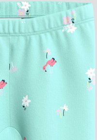 Hellblaue Leggings mit einem dehnbaren Bund, die mit pinken Flamingo- und Blumenmustern versehen sind. Weiche, strukturierte Stoffqualität.