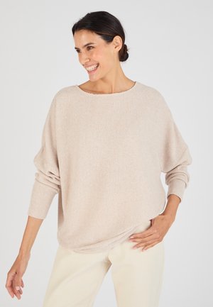 Maglione a collo ampio di un beige chiaro lavorato a maglia, dalla vestibilità comoda e con polsini a coste. Tessuto testurizzato con sottili righe, abbinato a pantaloni color crema.