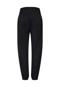 Sorte tilspidsede bukser med elastik i talje og manchetter, set bagfra mod en hvid baggrund.