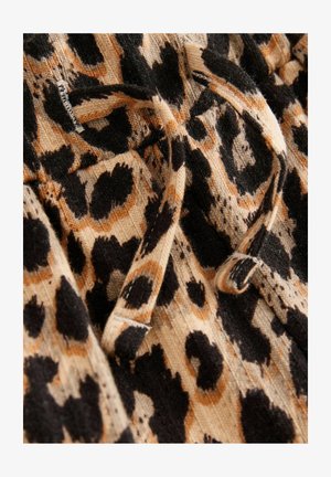 Tessuto a stampa leopardata in tonalità beige, nero e marrone, con fine rigatura e un dettaglio con cordoncino. Dettaglio del materiale morbido e testurizzato visibile.