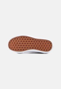 Λευκή σόλα αθλητικού παπουτσιού με σχέδιο κυψελίδας, με καφέ λαστιχένια εξωτερική σόλα. Ομαλές άκρες με ελαφριά καμπύλη στο μπροστινό και πίσω μέρος.