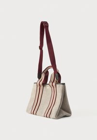 Μπεζ υφασμάτινη τσάντα tote με δύο φαρδιές κατακόρυφες χοιροστάσεις μπορντό και κρεμ και μία μακριά ρυθμιζόμενη μπορντό θήκη ώμου.