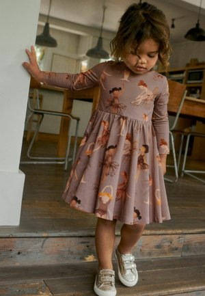 Langærmet kjole i afdæmpet mauve med en nederdel. Har illustrationer af dansere i varme nuancer. Kombinationen består af glitrende sølv sneakers.