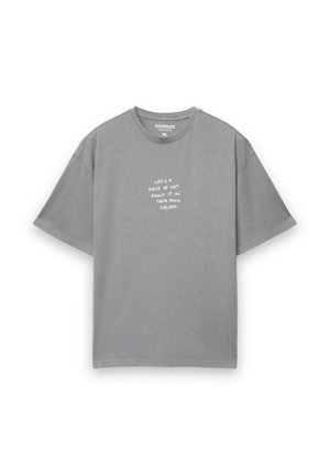 Szara, oversize koszulka z bawełny, z okrągłym dekoltem i krótkimi rękawami. Na białe napisy: "LIFE IS A PIECE OF ART."