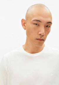 Wit katoenen T-shirt met een ronde hals, voorzien van een klein geborduurd logo op de borst en korte mouwen. Gladde textuur, aansluitende pasvorm.