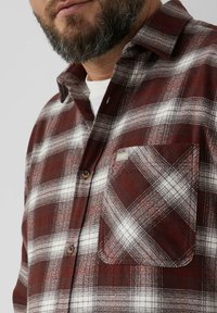 Rood-wit geblokt flanellen overhemd met een button-down kraag, voorzien van een enkele borstzak en een getextureerde stofafwerking.