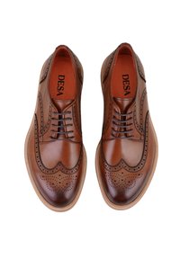 Chaussures de ville en cuir marron avec des détails en brogue, présentant un bout arrondi et une semelle en caoutchouc contrastante. L'intérieur est doublé en orange.