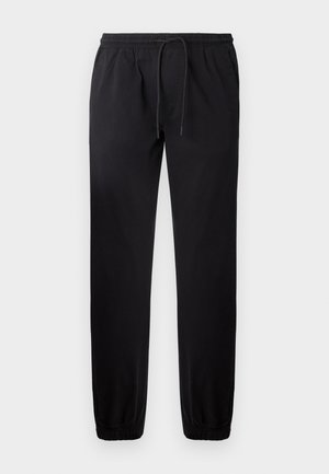 Pantaloni de jogging negri cu talie elastică și șnur reglabil. Manșete conice și material neted. Fără buzunare vizibile sau modele.