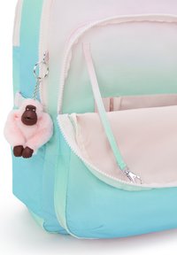 Zaino a gradiente nei toni del blu e del rosa, con un portachiavi a forma di scimmia in peluche, tasche con zip e un tessuto dalla texture liscia.