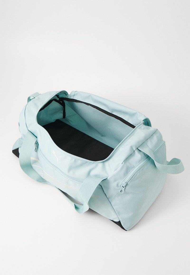 Borsa a forma di borsone blu chiaro con interno nero, chiusura con zip e due manici. Presenta un piccolo logo e una tasca frontale con zip. Tessuto testurizzato.