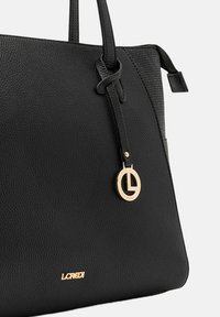 Borsa tote in pelle nera con finitura testurizzata, caratterizzata da un charm a logo circolare dorato e un nome del brand impresso alla base.
