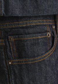 Vaqueros de mezclilla oscura con un diseño clásico de cinco bolsillos, costuras naranjas en contraste y detalles de hardware metálico en los bolsillos.