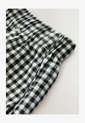 Black and white gingham fabric with an elastic waistband, featuring a gathered texture. The pattern consists of small squares arranged symmetrically.