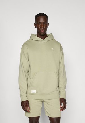 Lichtgroene hoodie met een gestructureerde stof en een zak aan de voorkant. Bevat een klein wit Puma-logo op de borst. Gecombineerd met bijpassende shorts.