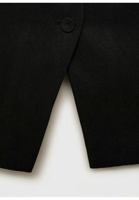 Černý, na míru šitý sako s jedním kulatým knoflíkem a čistým, špičatým designem klopy. Hladká textura s pevným střihem.