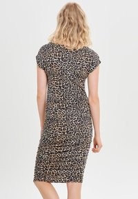 Šaty s leopardím potiskem, krátký rukáv, přiléhavý střih, vyrobené z měkké látky, se strukturovaným povrchem a na bocích řasenými detaily.