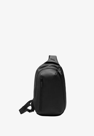 Schwarzer einriemiger Sling-Rucksack mit glatter Oberfläche, einer vorderen, vertikalen Reißverschlusstasche und einem verstellbaren Riemen vor weißem Hintergrund.