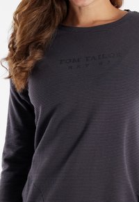 Maglietta a maniche lunghe grigio scuro con righe orizzontali, caratterizzata da testo del logo in rilievo "TOM TAILOR EST 67" sul davanti e scollatura comoda.