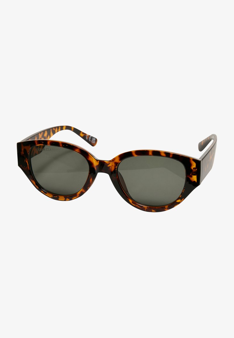 Gafas de sol estilo cat-eye en carey con lentes oscuros; cuentan con un marco de plástico grueso y brazos ligeramente acampanados con detalles del logo en las patillas.