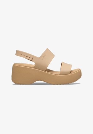 Sandalias cuña beige con tiras anchas, correa ajustable en el tobillo, suela texturizada y acabado suave. Material ligero con diseño minimalista.