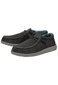 Szare materiałowe buty wsuwane z teksturowanym siateczkowym wzorem, elastycznymi sznurówkami i wyściółką w szarym kolorze. Wnętrze ma niebieski geometryczny wzór.