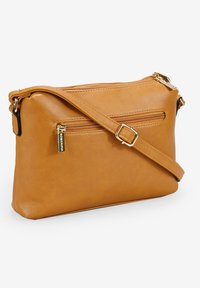 Bolso cruzado de cuero marrón claro con un bolsillo frontal con cremallera, correa ajustable y acentos de hardware dorado. Textura suave, forma rectangular.
