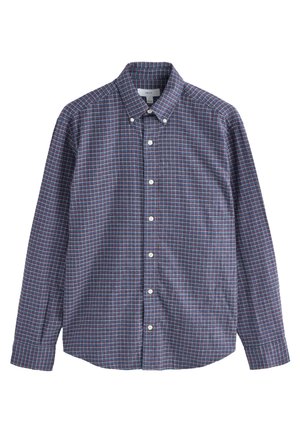 Chemise à manches longues boutonnée avec un motif à carreaux bleu, rouge et blanc et col boutonné, posée à plat sur fond blanc.