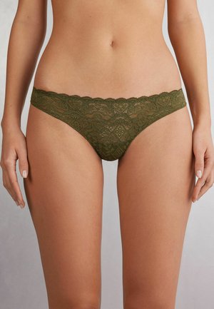 Olijfgroene kanten slip met bloemmotief, geschulpte tailleband en doorschijnende textuur. Ontworpen met minimale bedekking en ingewikkelde details.