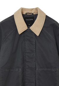 Giacca di tessuto nera con un colletto in corduroy beige. Presenta due tasche frontali e dettagli di cucitura in vista. Taglia etichettata come "S."