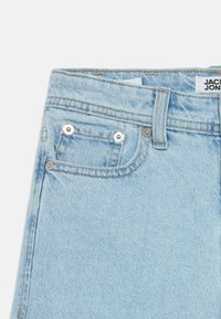 Ανοιχτό μπλε τζι ν παντελόνι με ψηλή μέση, με μπροστινό κλείσιμο με κουμπί, δύο μπροστινές τσέπες και αντίθετες ραφές.