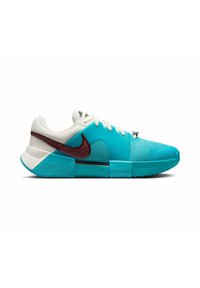 Scarpa sportiva teal e bianca con upper testurizzato, suola in gomma e accenti color maroon. Presenta un design unico con forme angolari e scanalature.