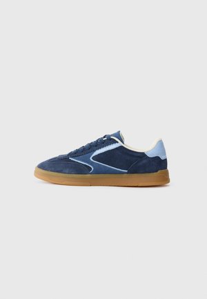 Dark blue suede sneakers with light blue accents, a rubber gum sole, and a rounded toe, featuring a lace-up front and textured side panels.