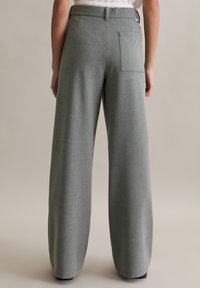 Szare spodnie z szerokimi nogawkami wykonane z fakturowanej tkaniny. Posiadają tylnią kieszeń oraz wysoki pas. Gładkie wykończenie i luźny krój.