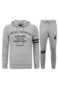 Grijze hoodie en trainingsbroek set, met zwarte tekstgraphics, gestreepte accenten op de mouwen en broek, en een zachte stoftextuur.