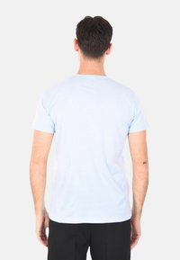 T-shirt di cotone azzurro chiaro con maniche corte e scollatura a girocollo. Design del retro semplice, texture morbida e vestibilità regolare.