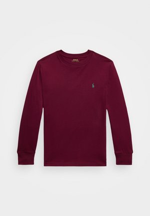 Burgundijas garspēdējs krekls no kokvilnas materiāla ar apaļu kakla izgriezumu un mazu zaļu izšūtu logo kreisajā krūšu daļā, ar pieguļošām piedurknēm.