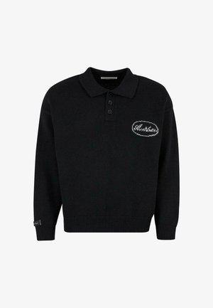 Melna adīta polo džemperis ar apkakli, trim pogām un baltu izšūtu nozīmi ar vārdu "Brāļi" uz krūtīm. Strukturēta auduma.