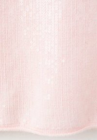 Tejido de punto rosa suave con sutiles lentejuelas blancas dispersas en un patrón vertical, creando un delicado efecto de brillo.