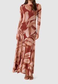 Maxi šaty v měděné barvě s velkými béžovými květinovými vzory. Vyrobené z hladké, lehké tkaniny, s dlouhými rukávy a splývavým siluetou.