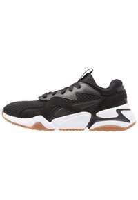 Schwarze Sportschuhe mit einem Obermaterial aus Mesh, Wildleder-Akzenten, dickem weißen Zwischensohlen und einer einzigartig gewölbten Sohle aus Gummi.