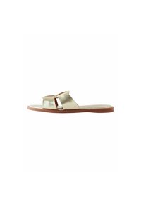 Metallisk guld sandal med et bredt, fladt stropdesign, åben tå og en lys brun sål. Har en simpel, ren kontur med minimal udsmykning.