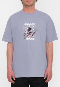Grijze katoenen T-shirt met korte mouwen, voorzien van een grafiek van een geklede figuur, omringd door bliksem en geometrische patronen in roze en zwart.