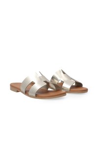 Sølv metallic sandaler med åben tå, udskæringsdesign og en flad brun sål. Glat tekstur med en minimalistisk stil.