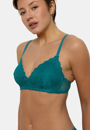 Bralette en dentelle turquoise avec des bords festonnés et des bretelles réglables. Présente des motifs floraux et une texture douce, offrant un design à coque triangulaire.