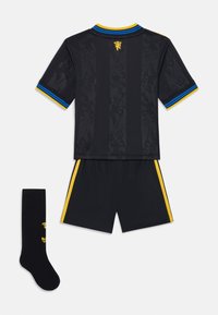 Maglia da calcio nera con una texture grafica sottile, dettagli gialli e blu su colletto e maniche, include pantaloni coordinati e calzettoni neri.